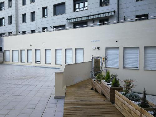 a building with a wooden walkway in front of a building at Apartamentos Antares 2 in Milladoiro