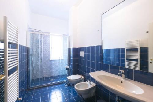 een blauw betegelde badkamer met een toilet en een wastafel bij Cozy Sorrento Apartment in Sorrento