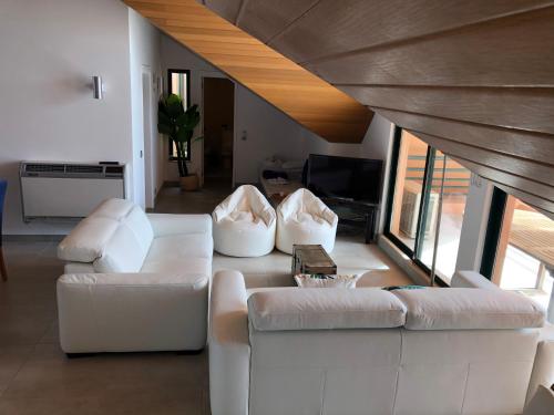 un salon avec deux canapés blancs et une télévision dans l'établissement Beach Apartment Marina Vilamoura, à Vilamoura