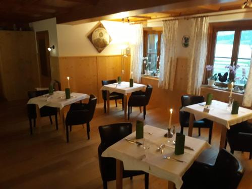 un restaurante con mesas y sillas con velas en Pension Ladner, en Grundlsee