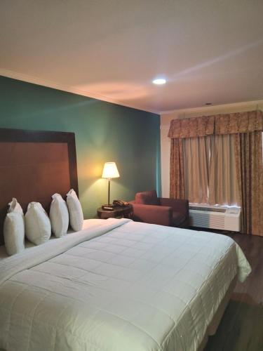 マディソンにあるDeerfield Inn & Suitesの白い枕が付いた大きなベッドがあるホテルの部屋