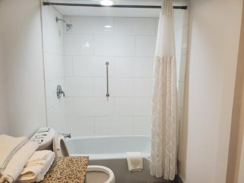 een badkamer met een wit bad en een douche bij Deerfield Inn & Suites in Madison