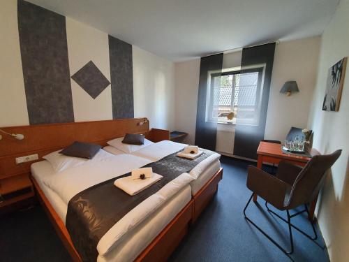 1 dormitorio con 1 cama grande y 2 toallas. en Waldhotel Surwold, en Surwold