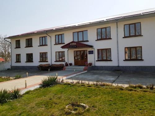a large white building with the front of it at Adina in Rîşcani