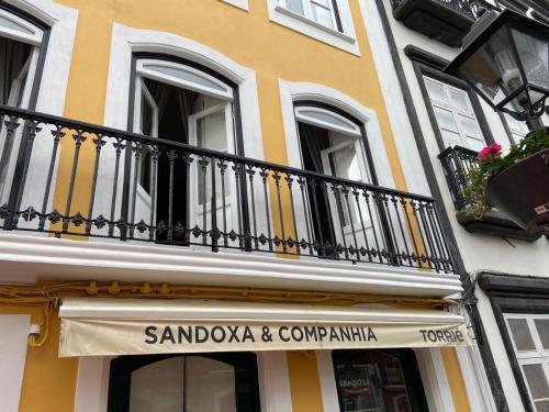 a yellow and white building with a balcony at Hotel Ilha in Angra do Heroísmo