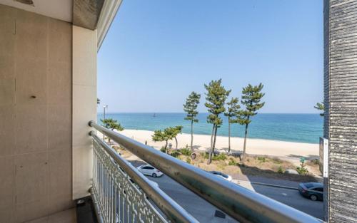 a balcony with a view of the beach at Gyeongpo Soo Hotel in Gangneung