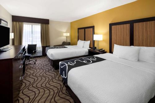 a hotel room with two beds and a desk at La Quinta by Wyndham LaGrange / I-85 in LaGrange