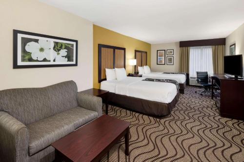 een hotelkamer met 2 bedden en een bank bij La Quinta by Wyndham LaGrange / I-85 in LaGrange