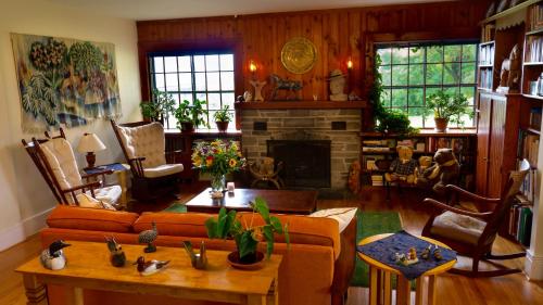 a living room with a couch and a fireplace at Enfield Manor Bed&Breakfast and Vacation Rental in Newfield