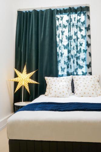 a bedroom with a bed with a green curtain at Blue Empire Hotel in Tokyo
