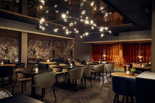 a restaurant with tables and chairs in a room at Van der Valk Hotel Arnhem in Arnhem
