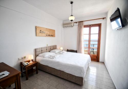 a bedroom with a bed and a television in it at Κastro Ηotel in Agios Kirykos