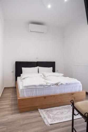 a bed with white sheets and a black headboard at Apartment One in Drama