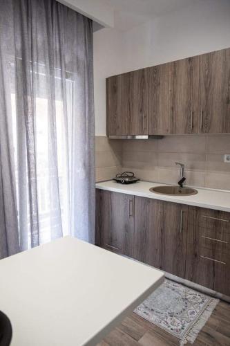 a kitchen with wooden cabinets and a sink and a window at Apartment One in Drama