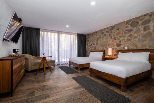 a hotel room with two beds and a couch at Hotel Boutique Camino Del Bosque by Rotamundos in Cholula