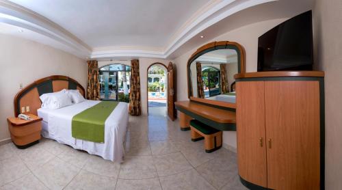 a hotel room with two beds and a television at Hotel Costa Azul in Acapulco
