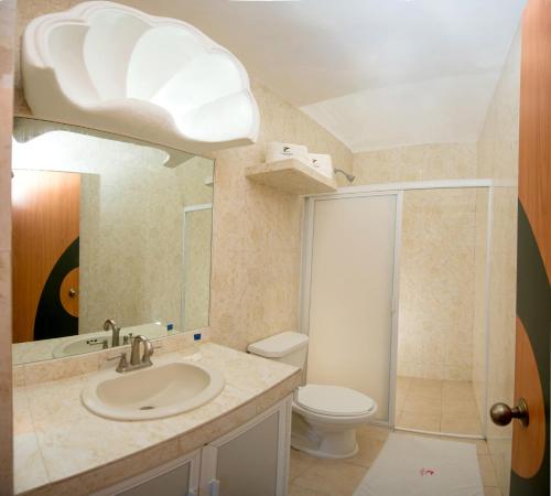 a bathroom with a toilet, sink, and shower at Hotel Costa Azul in Acapulco