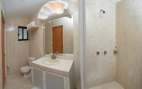 a bathroom with a sink and a shower and a toilet at Hotel Costa Azul in Acapulco