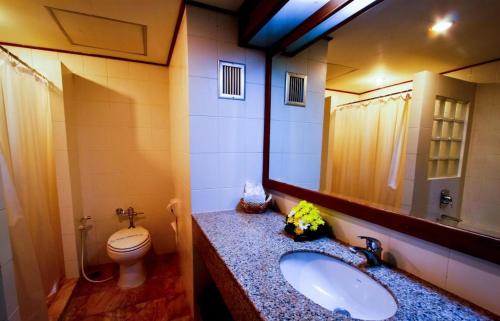 ein Badezimmer mit einem Waschbecken, einem WC und einem Spiegel in der Unterkunft Grand Park Hotel in Nakhon Si Thammarat