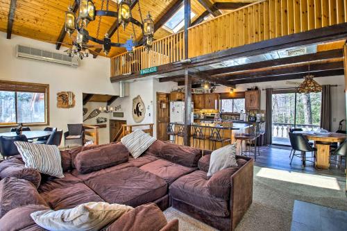 a living room with a couch and a kitchen at Swiss-Style Chalet with Fireplace - Near Story Land! in Bartlett