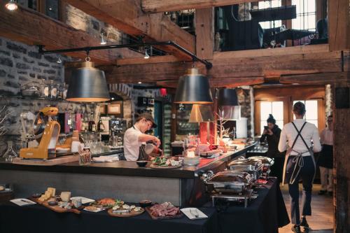 um chef a preparar comida numa cozinha de restaurante em Auberge Saint-Antoine em Cidade de Quebec