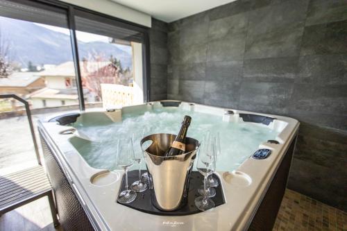 a bath tub with a bottle of wine in it at Chalet Hygge Saint Lary - gîtes de standing en coeur de village des Pyrénées in Saint-Lary-Soulan