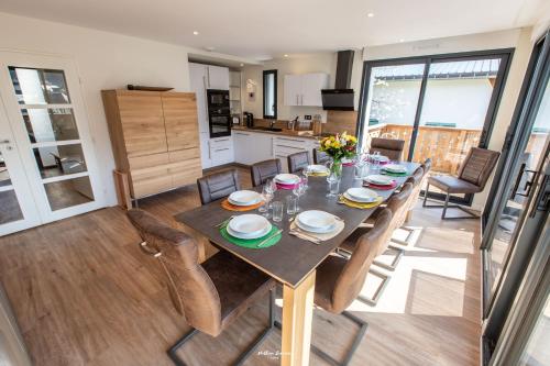 a kitchen and dining room with a table and chairs at Chalet Hygge Saint Lary - gîtes de standing en coeur de village des Pyrénées in Saint-Lary-Soulan