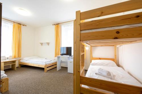 a bedroom with two bunk beds and a desk at Penzion Vědomice in Vědomice