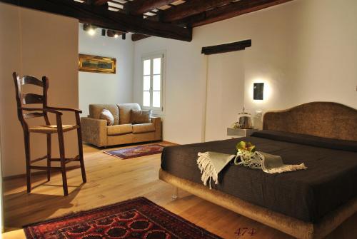 ein Schlafzimmer mit einem Bett und einem Stuhl in einem Zimmer in der Unterkunft Villa De' Giacomi in Teolo