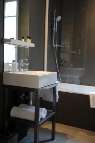 a bathroom with a sink and a shower and a tub at Arc de Triomphe Etoile in Paris