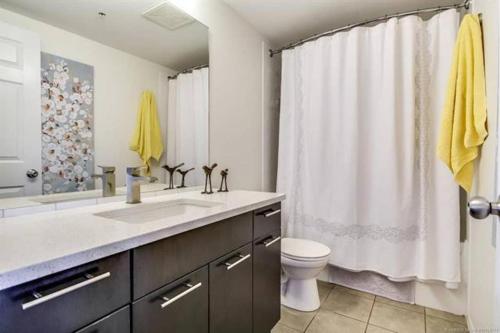 a bathroom with a sink and a toilet and a shower at Tranquil Waterfront Condo in Kelowna