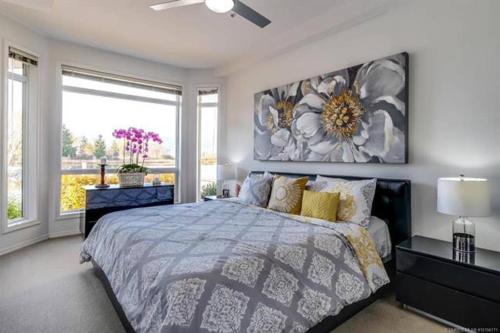 ein Schlafzimmer mit einem Bett und einem großen Fenster in der Unterkunft Tranquil Waterfront Condo in Kelowna