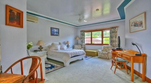 una camera con letto, tavolo e scrivania di Melville House Bed and Breakfast a Lismore