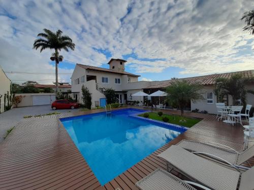 a swimming pool in front of a house at Pousada do Frei in Búzios