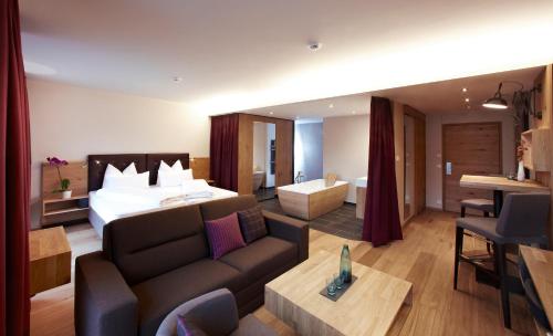Habitación de hotel con cama y sofá en Anthony's Life&Style Hotel en Sankt Anton am Arlberg