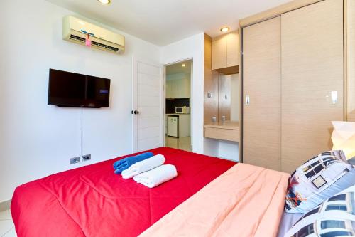 a bedroom with a red bed with towels on it at Paradise Park by Tech in Jomtien Beach