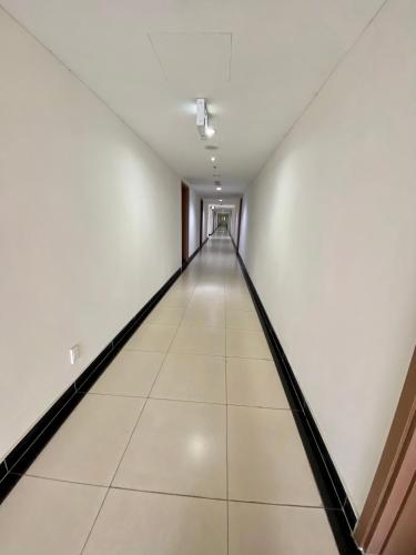 an empty corridor with white walls and a long hallway at SHP Plaza Khanh Phong Homestay in Hai Phong