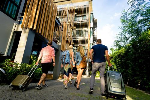 a group of people walking down a street with luggage at Nest by Sangob in Bangkok