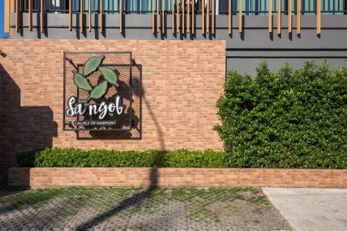a brick wall with a sign on it at Nest by Sangob in Bangkok