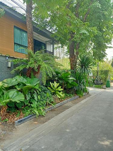 a garden in front of a house with plants at Nest by Sangob in Bangkok