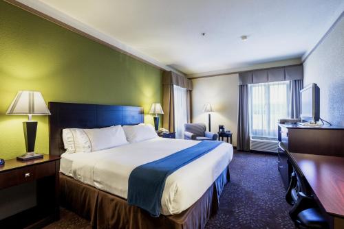 um quarto de hotel com uma cama grande e uma televisão em Holiday Inn Express Silver City, an IHG Hotel em Silver City