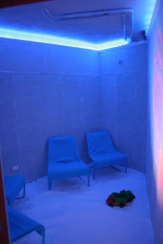a room with blue lights and two blue chairs at Hotel Relais Valle Orientina in Pitigliano