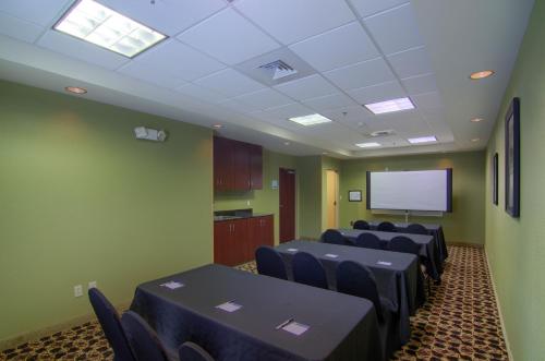 a conference room with black tables and chairs and a screen at Comfort Suites Mobile-South Alabama University Area in Mobile