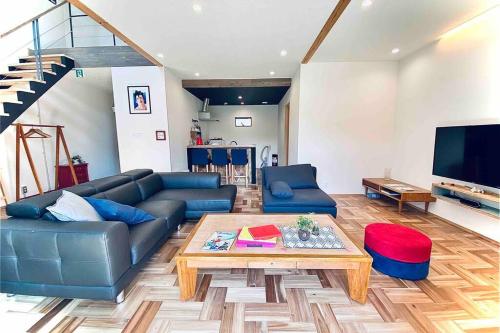 a living room with a couch and a coffee table at KANRA ichinomiya in Ichinomiya