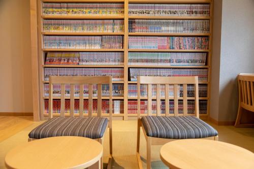 two chairs in front of a library with books at Dormy Inn Premium Fukui Natural Hot Spring in Fukui