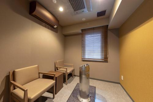 a waiting room with chairs and a radiator at Dormy Inn Premium Fukui Natural Hot Spring in Fukui