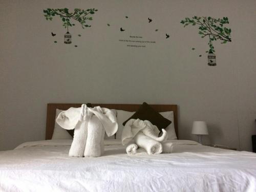 two stuffed animals sitting on top of a bed at ruamsab apartment1 in Bangkok