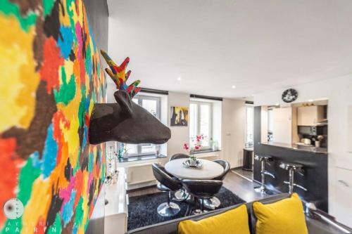 Il comprend une cuisine et un salon orné d'une peinture murale. dans l'établissement Appartement La Mazelle, à Metz