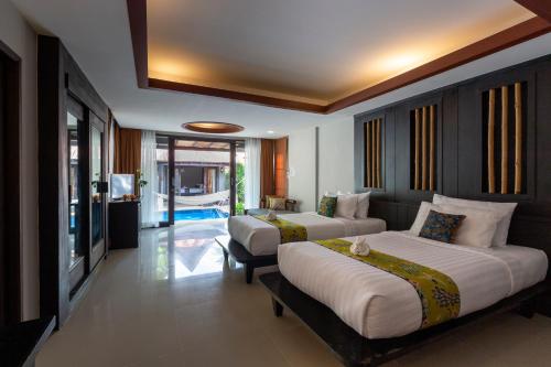 a bedroom with two beds and a living room at Railay Bay Resort & Spa in Railay Beach