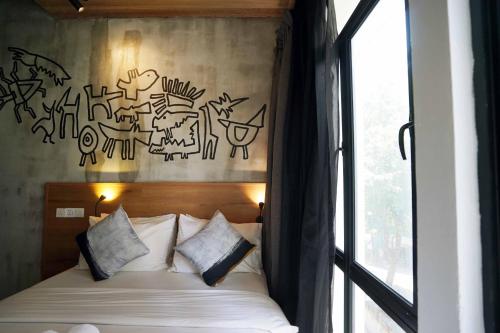 a bedroom with a bed with graffiti on the wall at Chaos Boutique Hotel Kuala Lumpur in Kuala Lumpur